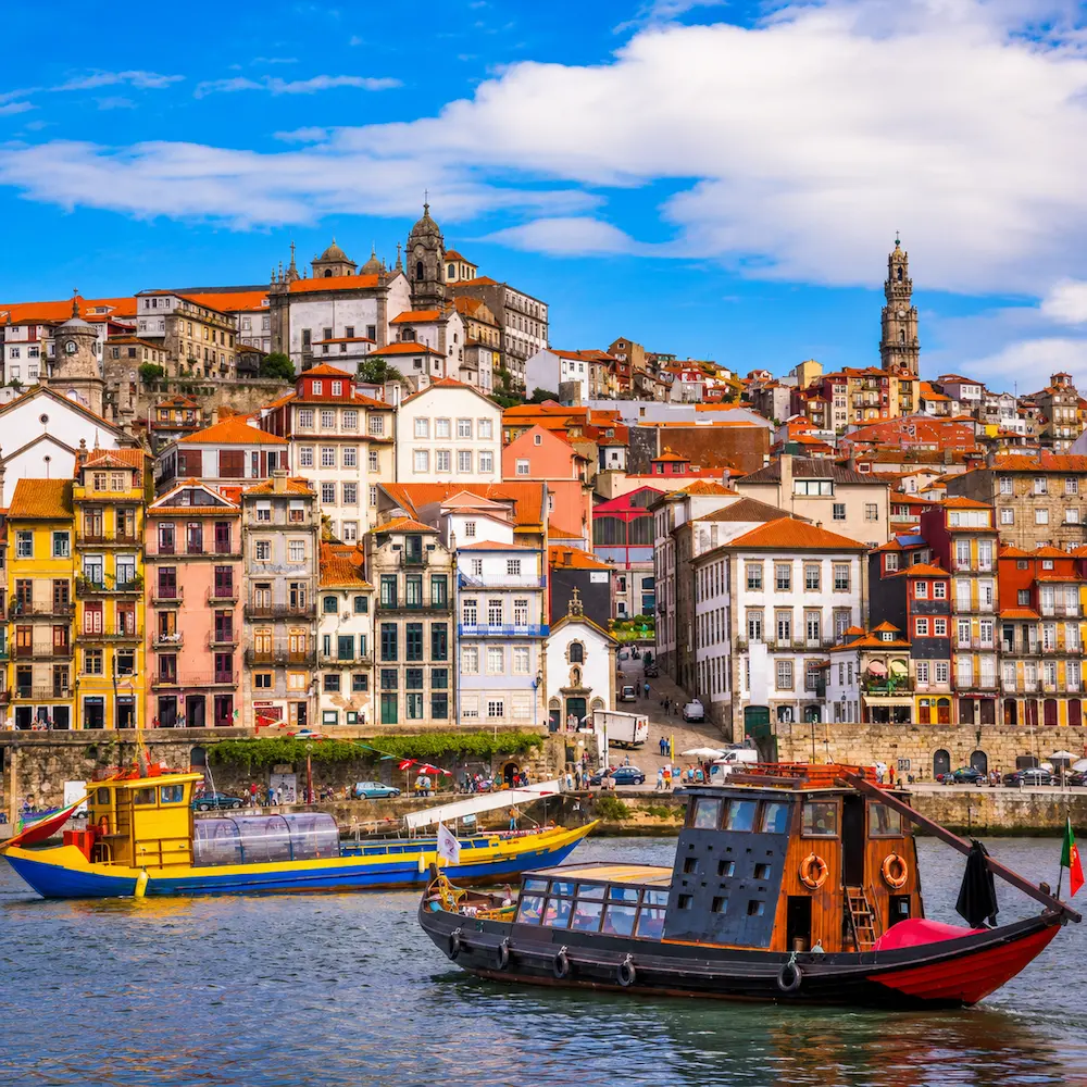 Viajantes observando um castelo português sobre colinas douradas